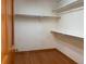 Spacious walk-in closet with built in storage shelving, wood base trim and laminate flooring at 1022 Morning Dove Dr, Longmont, CO 80504