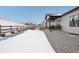 Backyard view with a fenced border, patio and gravel ground cover in a snow covered landscape at 5622 Shadescale Way, Castle Rock, CO 80104