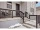 Charming front porch with dark railing, a seating area, steps leading to front door and modern brick accent at 5622 Shadescale Way, Castle Rock, CO 80104