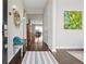 Inviting hallway with gleaming hardwood floors, decorative mirror, and a glimpse of the home's open-concept layout at 5622 Shadescale Way, Castle Rock, CO 80104