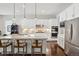 Modern white kitchen featuring stainless steel appliances, a large central island, and sleek countertops for culinary enthusiasts at 5622 Shadescale Way, Castle Rock, CO 80104