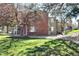Brick and siding condo building featuring well-maintained front lawn and mature trees at 857 S Van Gordon Ct # I207, Lakewood, CO 80228