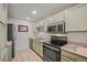 Efficient kitchen featuring green cabinets, modern appliances, and ample counter space for meal prep at 857 S Van Gordon Ct # I207, Lakewood, CO 80228