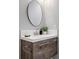 Modern bathroom featuring a wood grain vanity, a round mirror, and elegant fixtures at 9603 Marmot Ridge Cir, Littleton, CO 80125