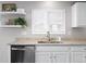 Close-up of the kitchen sink area with granite countertops and white cabinets at 9603 Marmot Ridge Cir, Littleton, CO 80125