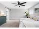 This main bedroom features plush carpet, a ceiling fan, and a sliding door leading to the ensuite bathroom at 9603 Marmot Ridge Cir, Littleton, CO 80125