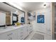 Elegant bathroom featuring dual sinks, white cabinets, modern lighting, and sophisticated decor at 7501 S Addison Way, Aurora, CO 80016