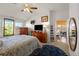 Bright bedroom showcasing artwork, ceiling fan, dresser, and view into the living room at 7501 S Addison Way, Aurora, CO 80016