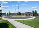 Well-maintained community clubhouse with lush greenery, round driveway, and ample parking at 7501 S Addison Way, Aurora, CO 80016