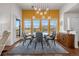 Bright dining room with backyard view, glass table, and modern chandelier at 7501 S Addison Way, Aurora, CO 80016