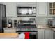 Kitchen features stainless steel appliances, gray cabinets, and stone countertops at 7501 S Addison Way, Aurora, CO 80016
