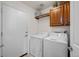 Laundry room with washer, dryer, overhead cabinet, and access door at 7501 S Addison Way, Aurora, CO 80016