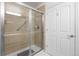 Tiled shower with glass doors and neutral finishes, next to a convenient storage area at 7501 S Addison Way, Aurora, CO 80016