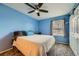 Bedroom featuring blue walls, plush carpeting, ceiling fan and sliding door closet at 10541 Routt St, Westminster, CO 80021