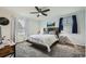 Bright bedroom featuring modern ceiling fan, two windows with blinds, and soft carpet at 10541 Routt St, Westminster, CO 80021