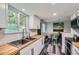 Modern kitchen features butcher block countertops, stainless steel sink, and updated white cabinetry at 10541 Routt St, Westminster, CO 80021