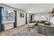 Bright living room features two large windows, cozy gray sectional sofa, and soft carpet at 10541 Routt St, Westminster, CO 80021