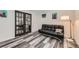 Living room featuring futon and doors to office space with modern black framed doors at 10541 Routt St, Westminster, CO 80021
