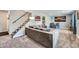Cozy living room featuring carpet floors, a comfortable gray couch, and a staircase at 10541 Routt St, Westminster, CO 80021