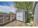 Backyard shed with grey siding and white trim near a wood fence and mature shade tree at 10541 Routt St, Westminster, CO 80021