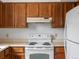 A close-up of the stove and cabinets in the kitchen with white appliances at 760 Century Pl # A, Monument, CO 80132