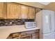 Kitchen area with microwave and white refrigerator at 15843 E 13Th Ave, Aurora, CO 80011