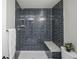 A beautiful renovated bathroom with modern tilework and a shower bench at 2504 S Yates St, Denver, CO 80219