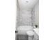 Updated bathroom featuring modern fixtures, marble tiled shower/tub, and neutral paint at 2504 S Yates St, Denver, CO 80219