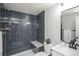 The newly remodeled bathroom features dark tile in the shower, a marble top vanity and modern fixtures at 2504 S Yates St, Denver, CO 80219