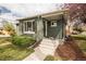 Inviting entrance to home with a gray brick exterior and well-maintained landscaping at 2504 S Yates St, Denver, CO 80219