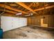 View of the garage interior, showing open rafters, lighting, and an overhead door at 2504 S Yates St, Denver, CO 80219