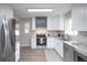 Well-lit kitchen features modern appliances, white cabinets, and stone countertops at 2504 S Yates St, Denver, CO 80219