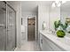 Elegant main bathroom with dual sinks, quartz countertop, glass shower, and walk-in closet at 716 N Carrie Ct, Watkins, CO 80137