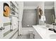 Stylish bathroom with striped walls, modern vanity, shower over tub, and decorative wall hangings at 716 N Carrie Ct, Watkins, CO 80137