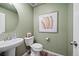 Charming powder room features a pedestal sink, stylish mirror, and tasteful wall decor at 716 N Carrie Ct, Watkins, CO 80137