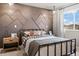 Cozy bedroom featuring a mountain-themed accent wall, metal bed frame, and natural light from a window at 716 N Carrie Ct, Watkins, CO 80137