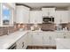 Contemporary kitchen with white cabinets, quartz countertops, and stainless steel appliances at 716 N Carrie Ct, Watkins, CO 80137