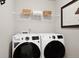 Functional laundry room with modern washer and dryer, shelving, and minimalist decor at 716 N Carrie Ct, Watkins, CO 80137
