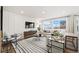 Bright and airy living room with a comfortable sofa, modern accents, large windows, and stylish striped rug at 716 N Carrie Ct, Watkins, CO 80137