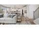 Open-concept living space featuring hardwood floors, a comfortable sofa, and seamless flow into dining and kitchen areas at 716 N Carrie Ct, Watkins, CO 80137