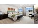 Serene main bedroom boasts ample natural light, decorative wall panels, and comfortable furnishings at 716 N Carrie Ct, Watkins, CO 80137