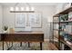 Serene home office with natural light, modern desk, decorative shelving, and minimalist decor, ideal for focused work at 716 N Carrie Ct, Watkins, CO 80137