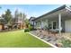 Expansive backyard with covered patio, deck, artificial turf, and lush landscaping, ideal for relaxation and entertainment at 4218 S Alton St, Greenwood Village, CO 80111