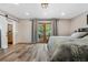 Spacious bedroom with wood floors, slider to deck, and access to ensuite bathroom via sliding barn door at 4218 S Alton St, Greenwood Village, CO 80111