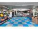 Spacious garage with a blue and grey checkered floor and equipped with storage solutions and a workbench at 4218 S Alton St, Greenwood Village, CO 80111