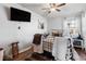 Comfortable bedroom featuring a metal bed frame, wood floors, ceiling fan, and a wall-mounted TV at 4389 S Sherman St, Englewood, CO 80113