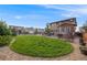 Backyard with manicured lawn, garden bed, hot tub, fire pit, and outdoor kitchen at 14384 Big Stone Dr, Parker, CO 80134