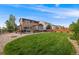 Large, well-maintained backyard with a patio, outdoor seating, a hot tub, and a grassy area perfect for entertaining at 14384 Big Stone Dr, Parker, CO 80134