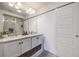 Bathroom featuring double sinks, a large mirror, and a sliding barn door with access to the glass shower at 14384 Big Stone Dr, Parker, CO 80134