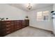 Bright bedroom features natural light from a window and dark wood dresser with decorative chandelier at 14384 Big Stone Dr, Parker, CO 80134